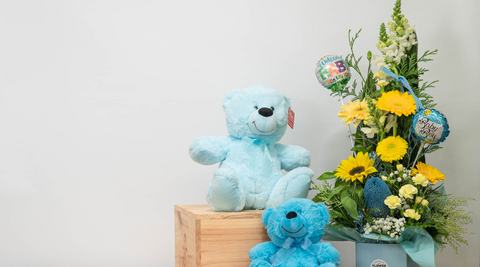 image of baby boy new baby flowers bouquet in yellows and green with two blue teddy bears on a white background