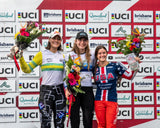 the three female BMX World Champions on the podium holding The Flower Farm podium flower arrangements