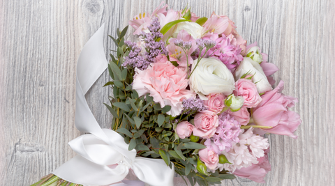 white washed wooden table with pink and white bunch of valentine’s day flower delivery