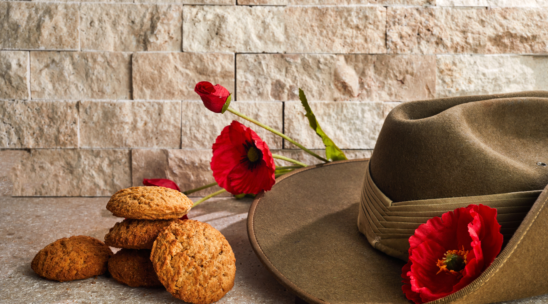 Image of a ANZAC hat with Anzac biccies and red poppies for when to send flowers for Anzac Day