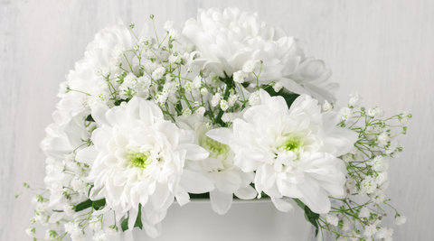 close up of white flower bouquet featuring chrysanthemums against an all white background