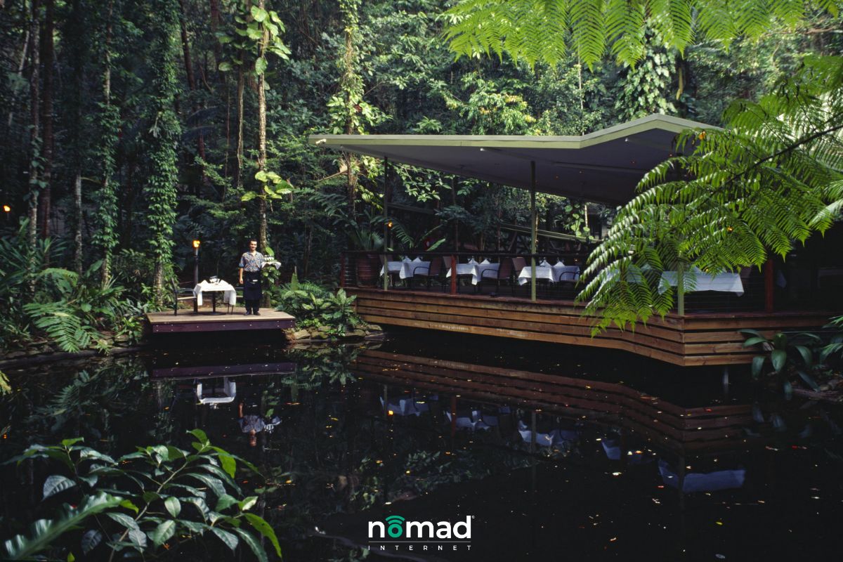 Eco lodging options: Lodge with lush plants next to water.  