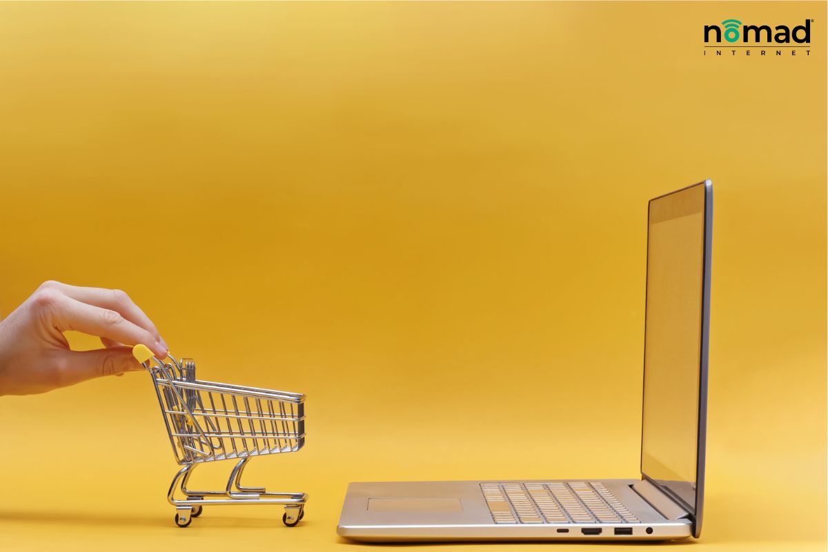 A laptop with a small shopping trolley.