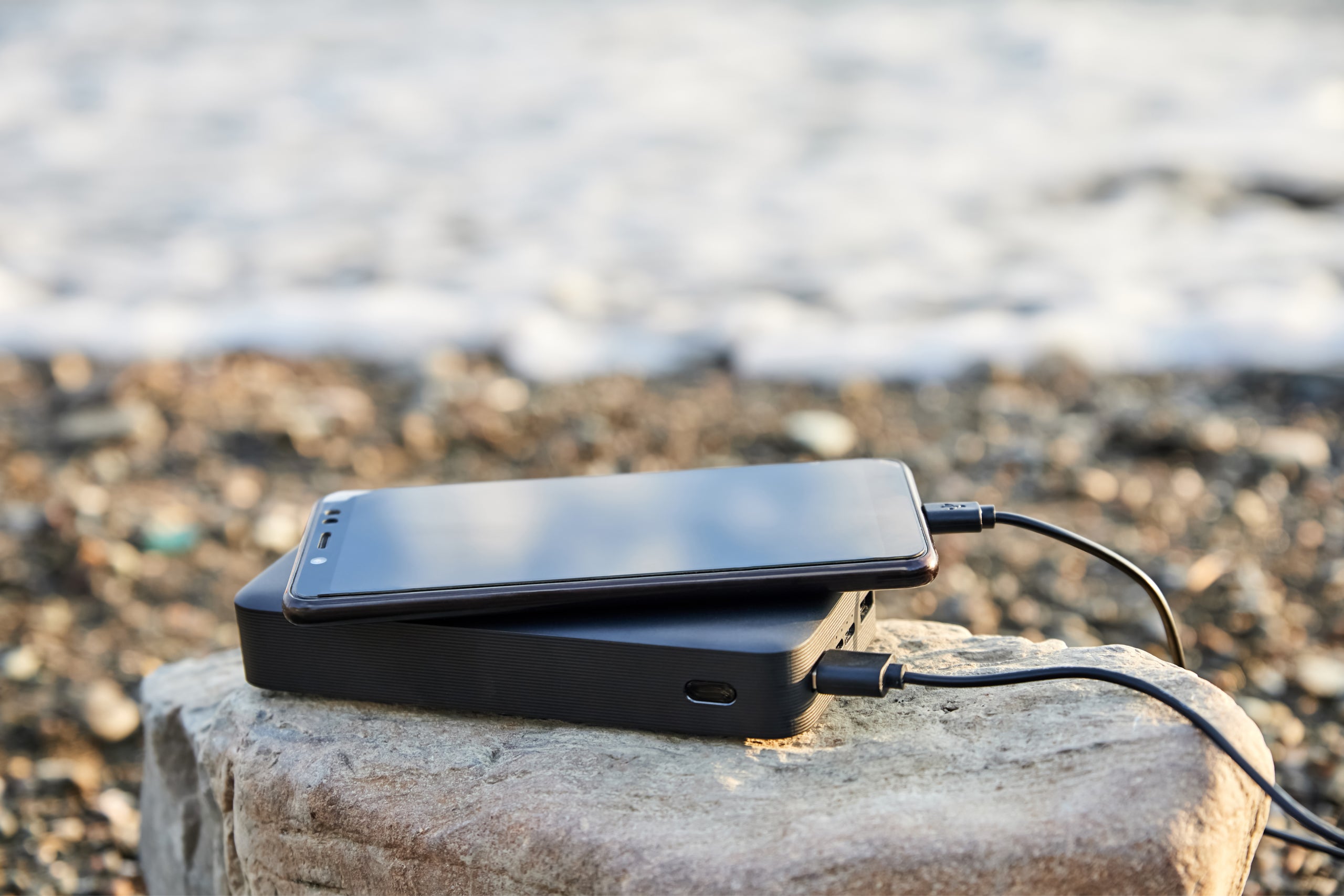 Powerbank charges phone beach by sea