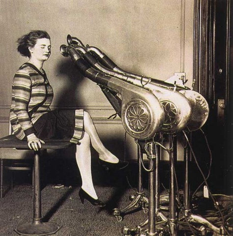 1950s woman having her hair dried by oversized hair dryers representing the equivalent heat put out by an electric bed bug heater