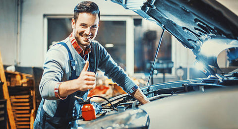 Smiling auto mechanic repairing his cars engine similar to PestPro customers repairing their own bed bug heaters