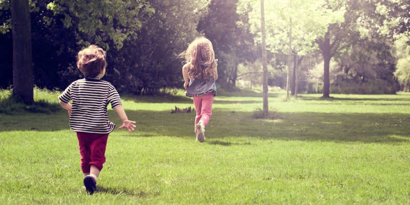 Two children running in park