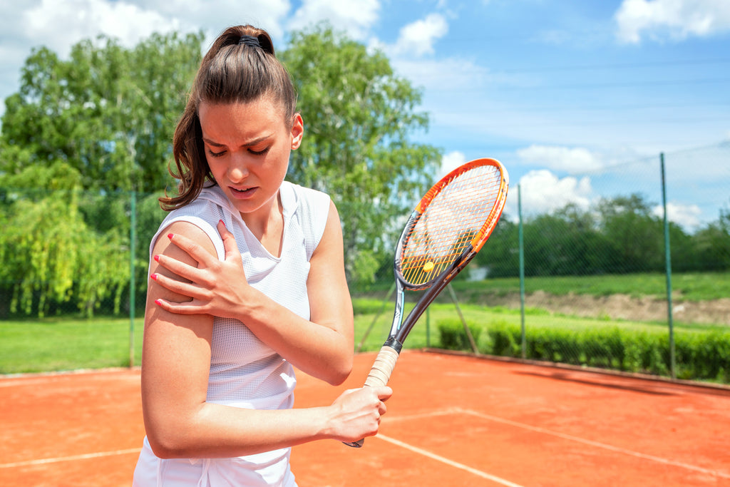 Woman suffering from frozen shoulder tennis injury