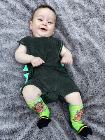 Baby wearing cute green  baby dragon socks.