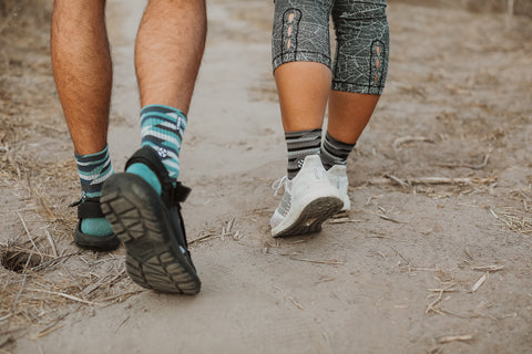 Two people hiking on a hiking trail wearing MERGE4's Trekker Quarter Crew Athletic socks