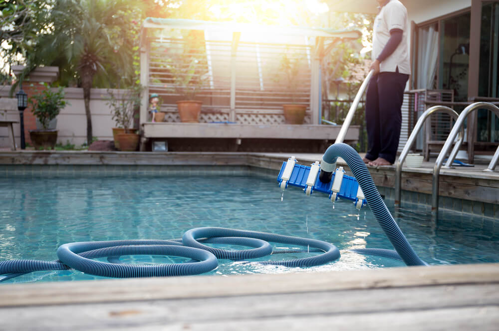 A pool maintenance man cleaning the pool to keep a normal flow rate.