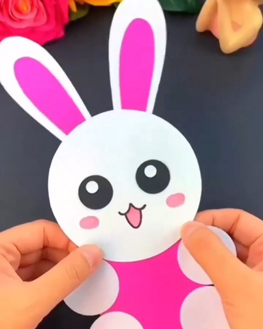 A handmade paper Easter bunny crafted with care, featuring a pink nose, expressive eyes, and whimsical ears. The bunny is placed on a festive surface, ready to bring joy to Easter celebrations.
