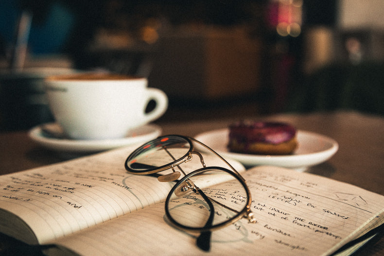 Eyeglasses on top of notebook in a Phil & Sebastian coffee shop