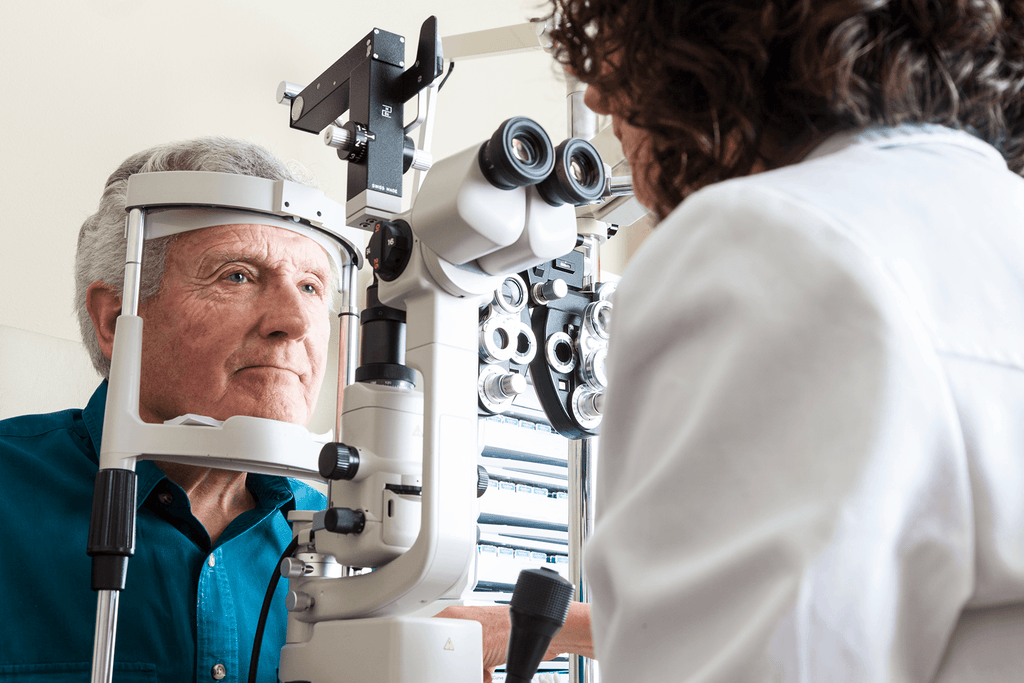 Elderly gentlemen getting his eyes analyzed by an ophthamologist