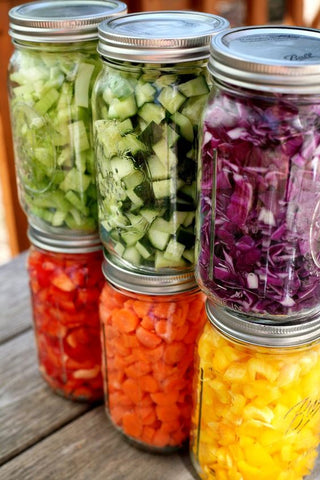 chopped and prepped vegetables organised in glass jars - mise en place style