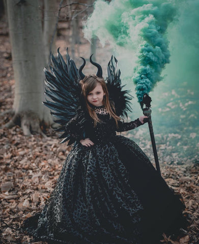 girl dressed in a halloween costume with teal smoke in the background