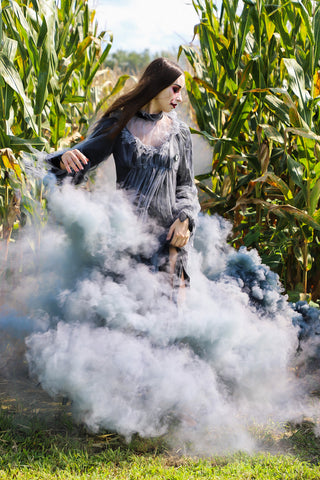 girl dressed in a zombie costume with a black fog effect behind her, made by smoke bombs