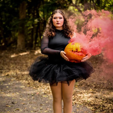 A girl holding a pumpkin with pink smoke and pink fog effects