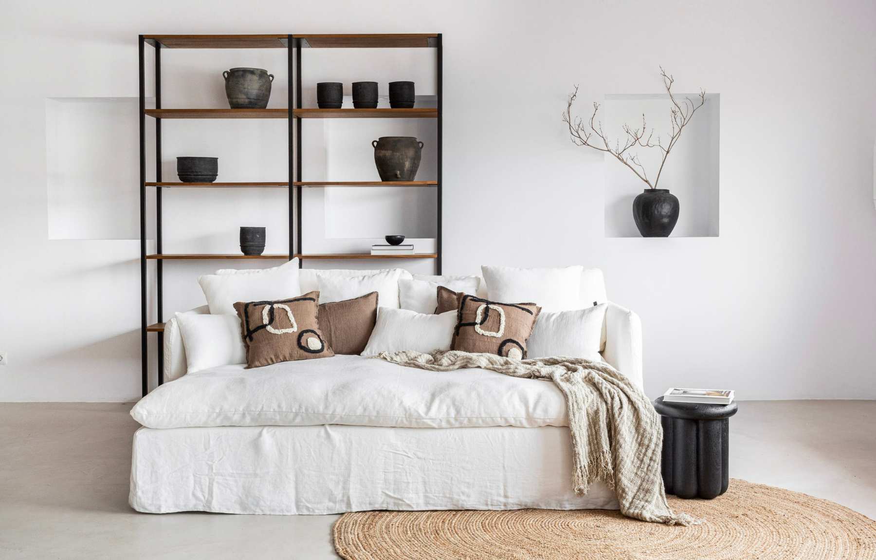 Living room with scandinavian style white linen sofa and brown linen cushions