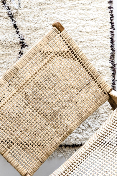 Natural rattan lounge chair on Beni Ourain rug