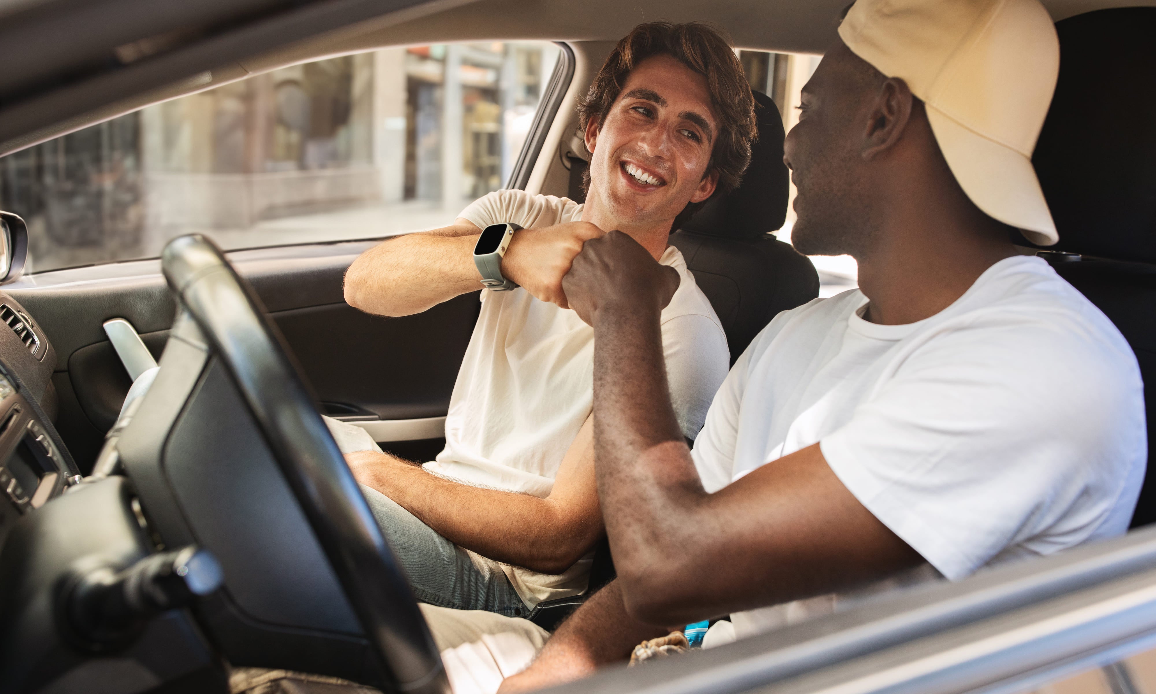 The Ultimate Guide to Joining an International Automobile Drivers Club: Fuel Your Passion for Driving Around the World, Cool multiethnic guys sitting inside car, giving fist bump