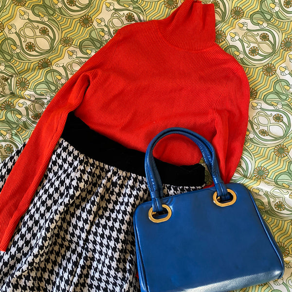 Orange polo neck, dogtooth print skirt and blue handbag, all found at a clothes swap