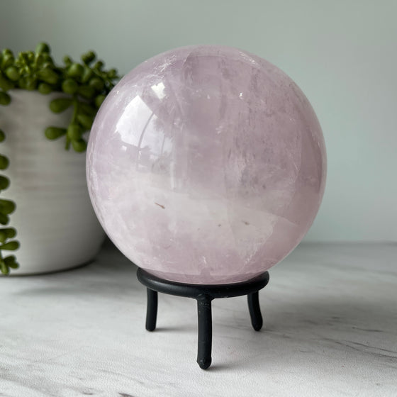 rose quartz stone crystal sphere on metal stand