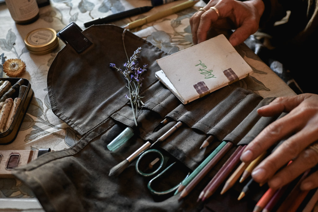 Waxed Canvas Sendak Artist Roll filled with pencils and pens with handmade sketchbook