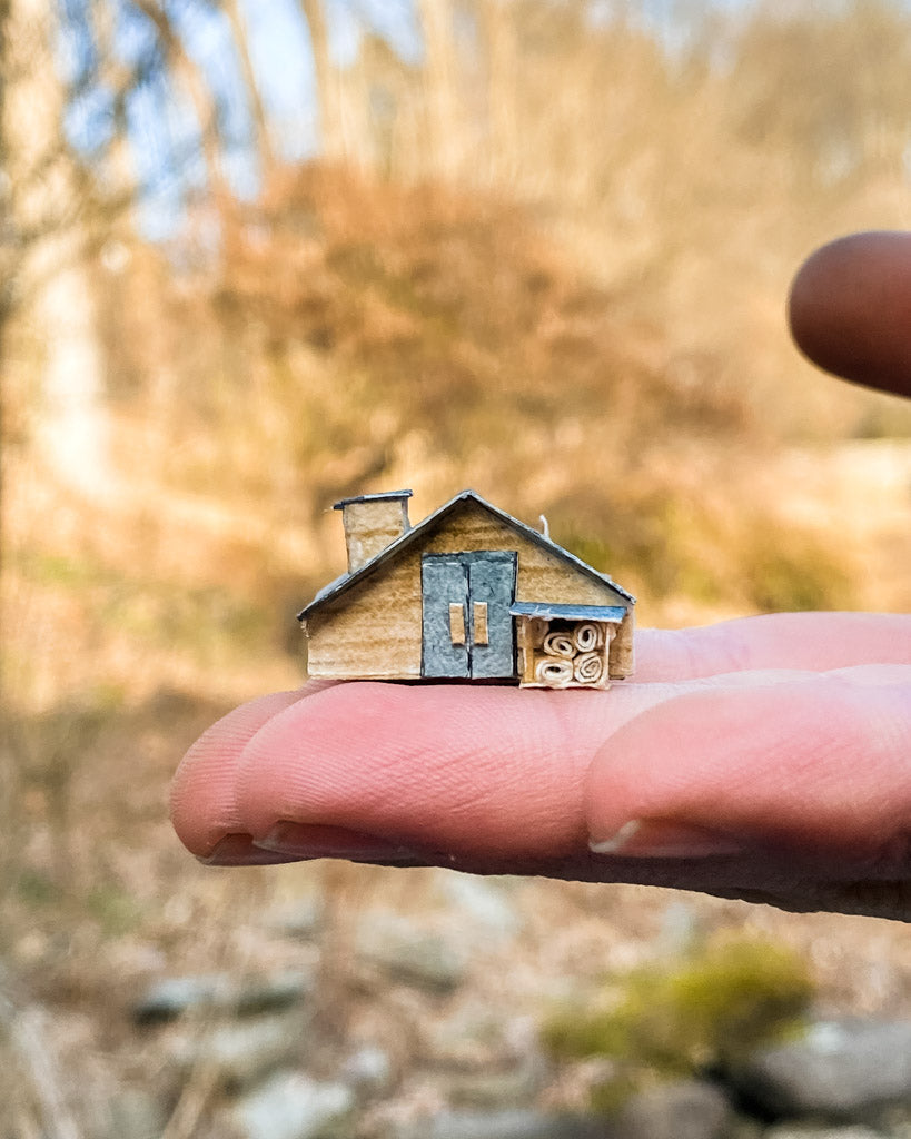 paper cut log cabin with wood pile and chimney