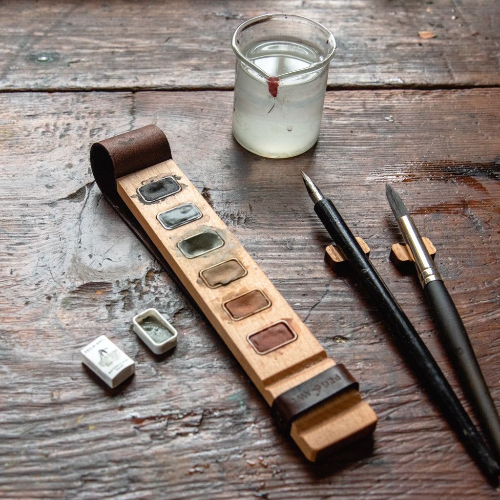 handmade wooden paint palette, watercolour paint, and brush rest