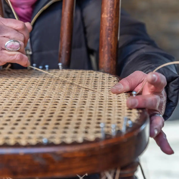 Handwerker webt Rattansitz