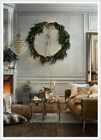 Green wreath hanged to a wall in a room with silver and gold color scheme.