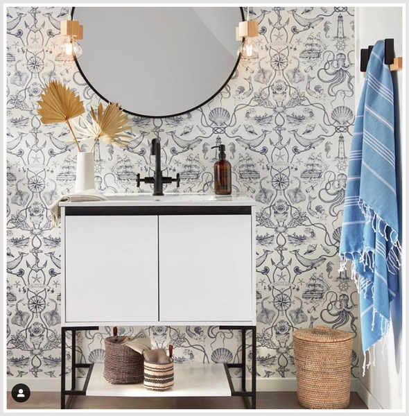 Round mirror attached to the wall above a bathroom counter.