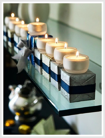 Hanukkah holiday decor with blue and silver ornaments and candles set on top gift boxes.