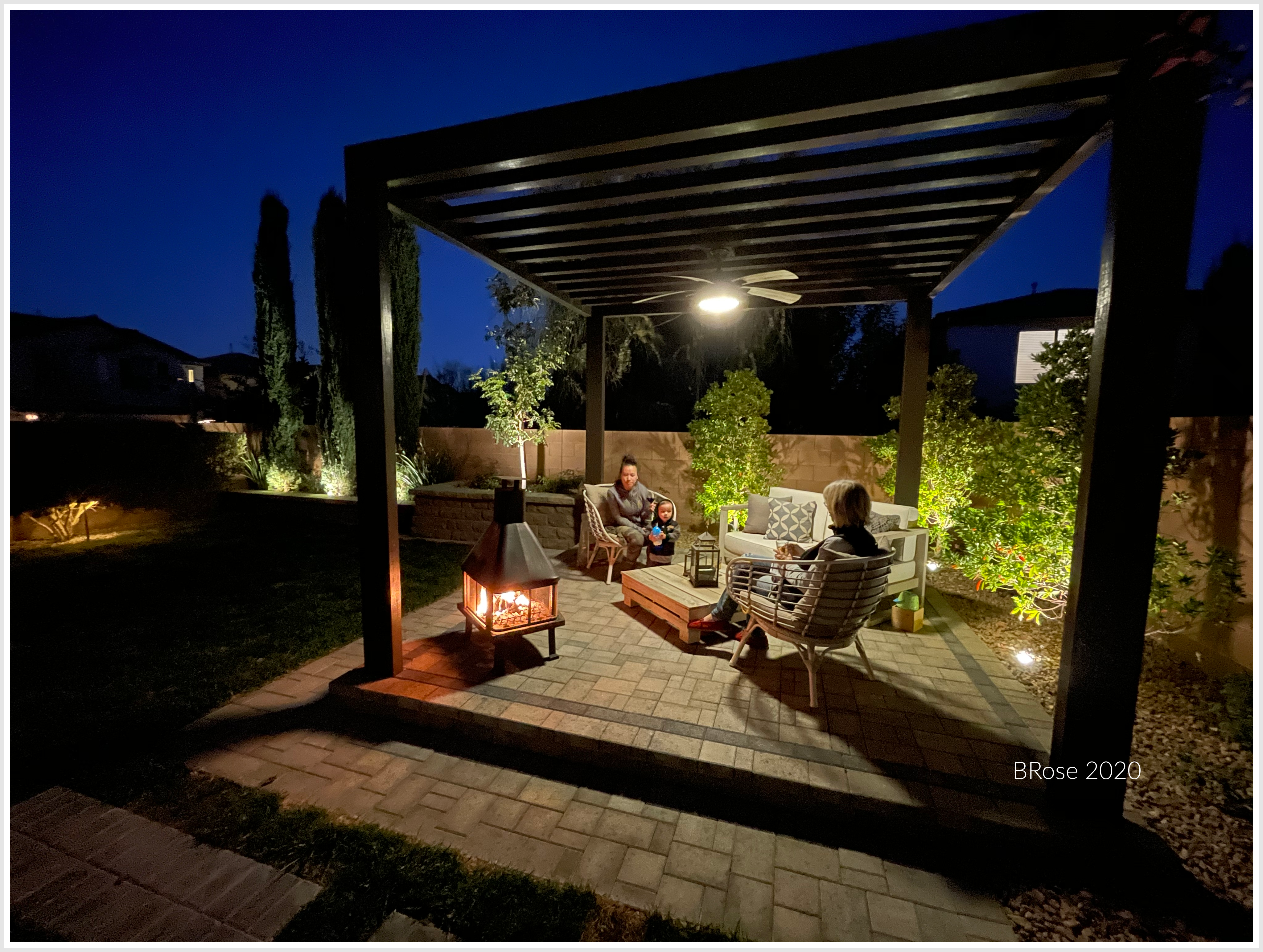 People sitting under a gazebo at night.