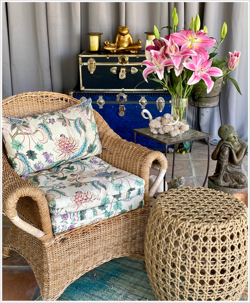 A wicker chair next to wicker side table.