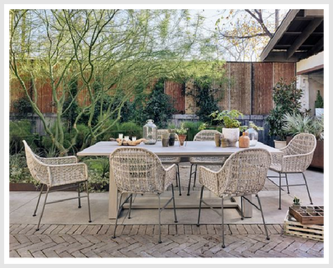 A set of four elegant dining chairs in cream color and dark legs in an outdoor area