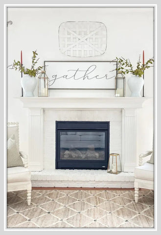 Lanterns framing artwork on either end of a mantel