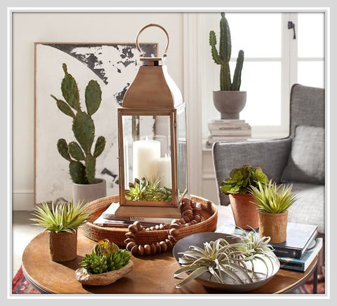 Brass lantern on wooden tray with accessories on coffee table