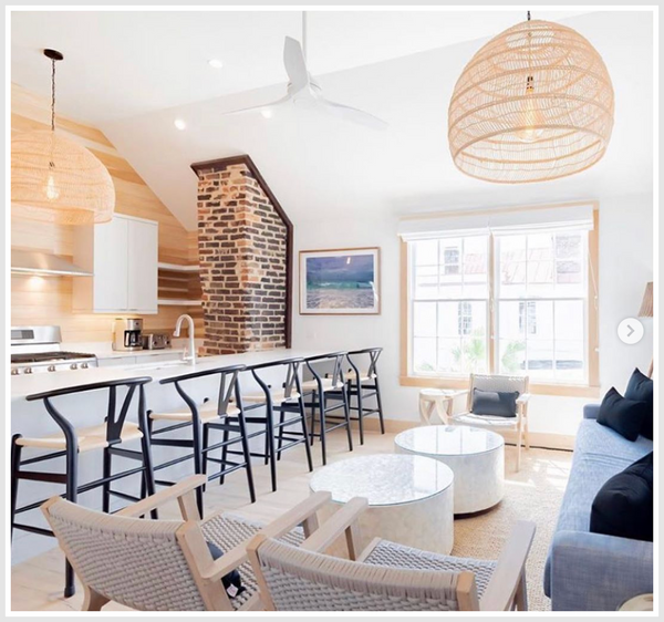 A contemporary open kitchen and living room space decorated with bamboo pendant lights.