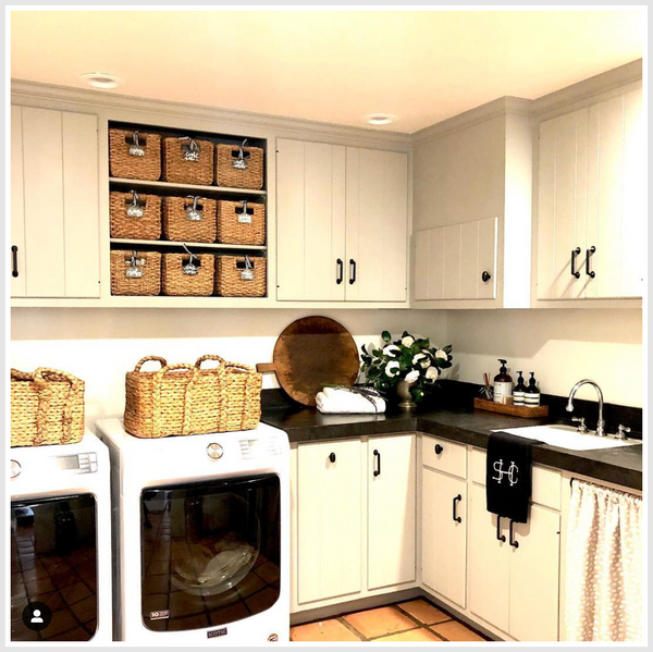 Room with sink and white cupboards, baskets standing on appliances