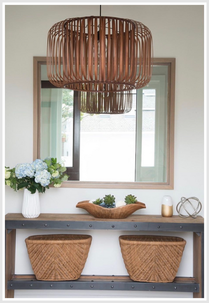 Pendant light, mirror in the background above 2 woven baskets.