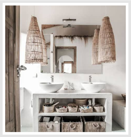 Bathroom with storage baskets under the sink, mirror and woven pendant lights.