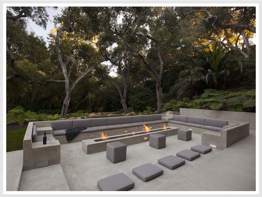 A modern outdoor entertaining space with a fire pit, concrete seating area.