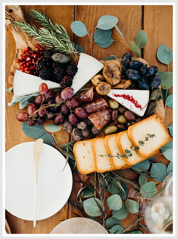 Tapas board with assorted snacks on it.