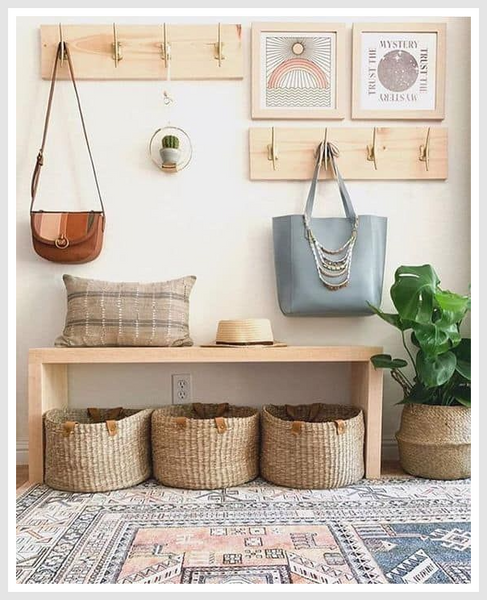 An entryway with a wooden bench and woven baskets under it.