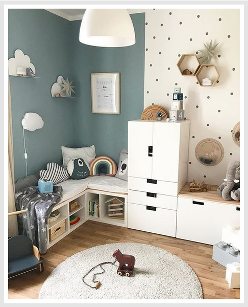 A playroom with a variety of toys, and a white storage unit.