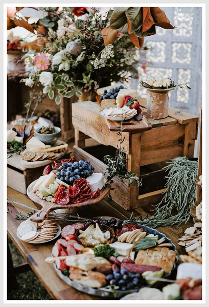 A rustic table full of delicacies, decorated with plants.