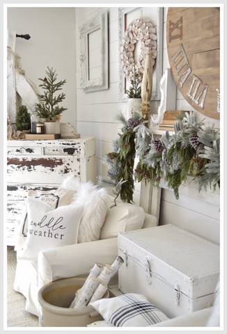 White-colored living room styled with Christmas tree branches.