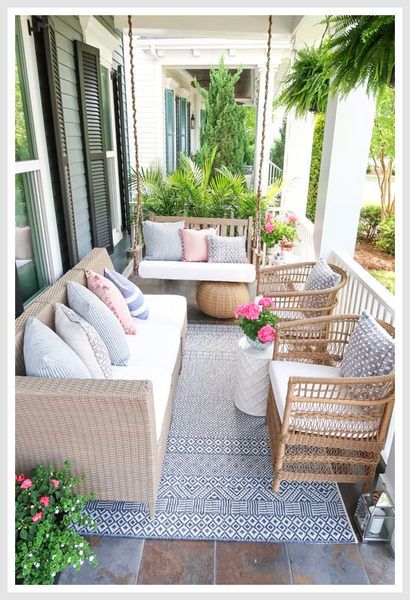 A front porch with rattan furniture.